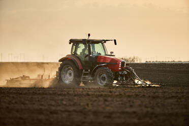 Landwirt im Traktor beim Kultivieren und Pflügen eines Feldes - NOF00913