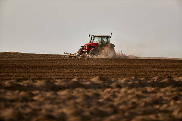 Traktor beim Kultivieren und Pflügen eines Feldes im Frühjahr - NOF00914