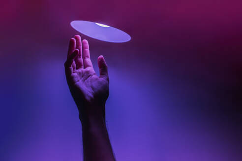 Hand of man under neon lighting against colored background - EGHF00825