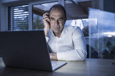 Smiling freelancer having video call on laptop at home office - UUF31062