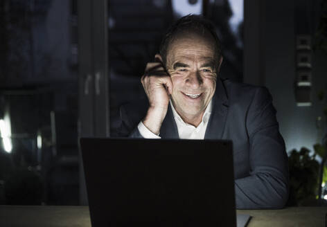 Happy freelancer talking on video conference through laptop at home office - UUF31070