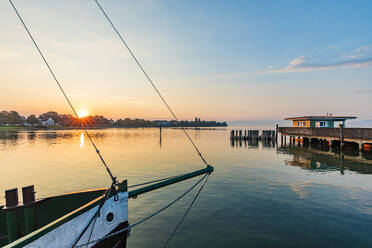 Deutschland, Baden-Württemberg, Langenargen, Pier am Bodensee bei Sonnenaufgang mit Schiffsbug im Vordergrund - WDF07506