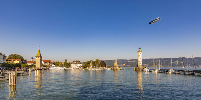 Deutschland, Bayern, Lindau, Yachthafen der Stadt am Ufer des Bodensees mit einem fliegenden Luftschiff im Hintergrund - WDF07513