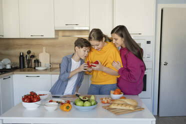 Girl preparing food with friends in kitchen at home - LESF00521