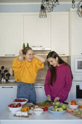 Fröhliche Freunde bei der Zubereitung von Speisen in der Küche zu Hause - LESF00524