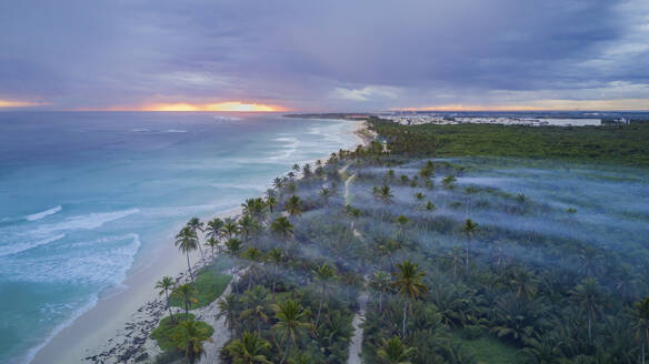 Luftaufnahme einer langen Küstenlinie mit Strand bei Sonnenuntergang in Punta Cana, La Altagracia, Dominikanische Republik. - AAEF25141