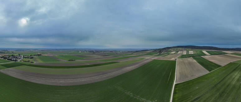 Panoramaluftaufnahme von Ackerland mit Hügeln und einem Wald in der Ferne an einem bewölkten Tag, Stockerau, Niederösterreich, Österreich. - AAEF25302