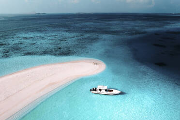 Luftaufnahme von Menschen mit einem Motorboot auf einer Sandbank entlang der Küstenlinie mit weißem Sandstrand, Süd-Ari-Atoll, Malediven. - AAEF25464