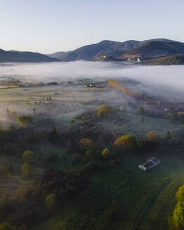 Luftaufnahme eines nebelverhangenen Tals im Frühnebel zwischen Bergen in Psaka, Epirus, Griechenland. - AAEF25470