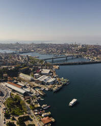 Luftaufnahme eines Bootes, das entlang der Mündung des Goldenen Horns in der Nähe der Galata-Brücke und der Atatürk-Brücke fährt, Istanbul, Türkei. - AAEF25521