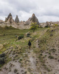 Luftaufnahme einer Frau bei einem Spaziergang im Tal der Liebe in Goreme, Kappadokien, Nevsehir, Türkei. - AAEF25566