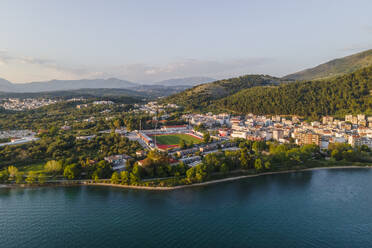 Luftaufnahme des städtischen Stadions von Igoumenitsa entlang der Bucht bei Sonnenuntergang, Epirus, Griechenland. - AAEF25652