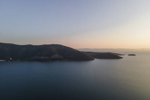 Luftaufnahme der Landzunge von Igoumenitsa bei Sonnenuntergang am Ionischen Meer mit der Insel Korfu im Hintergrund, Epirus, Griechenland. - AAEF25655