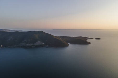 Luftaufnahme der Landzunge von Igoumenitsa bei Sonnenuntergang am Ionischen Meer mit der Insel Korfu im Hintergrund, Epirus, Griechenland. - AAEF25658