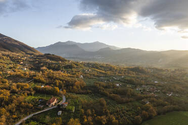 Aerial view of a mountains and hills landscape with vineyard and countryside houses at sunset in autumn colours, Irpinia, Avellino, Campania, Italy. - AAEF25735