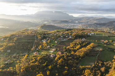 Aerial view of a mountains and hills landscape with vineyard and countryside houses at sunset in autumn colours, Irpinia, Avellino, Campania, Italy. - AAEF25745