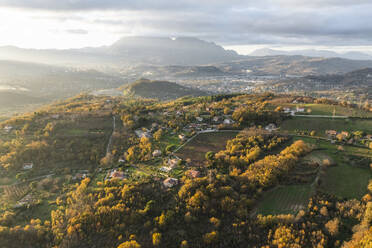 Luftaufnahme einer Berg- und Hügellandschaft mit Weinbergen und Häusern auf dem Land bei Sonnenuntergang in Herbstfarben, Irpinia, Avellino, Kampanien, Italien. - AAEF25745