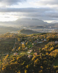 Luftaufnahme einer Berg- und Hügellandschaft mit Weinbergen und Häusern auf dem Land bei Sonnenuntergang in Herbstfarben, Irpinia, Avellino, Kampanien, Italien. - AAEF25746