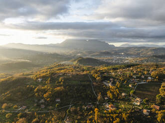 Aerial view of a mountains and hills landscape with vineyard and countryside houses at sunset in autumn colours, Irpinia, Avellino, Campania, Italy. - AAEF25747