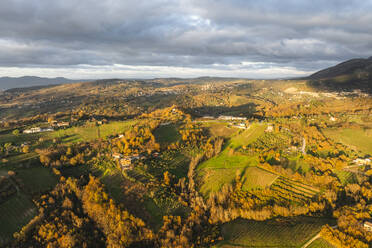 Luftaufnahme einer Berg- und Hügellandschaft mit Weinbergen und Häusern auf dem Land bei Sonnenuntergang in Herbstfarben, Irpinia, Avellino, Kampanien, Italien. - AAEF25748