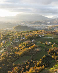 Luftaufnahme einer Berg- und Hügellandschaft mit Weinbergen und Häusern auf dem Land bei Sonnenuntergang in Herbstfarben, Irpinia, Avellino, Kampanien, Italien. - AAEF25752