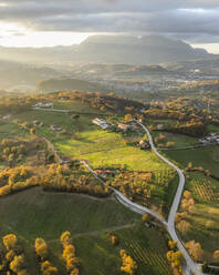 Luftaufnahme einer Berg- und Hügellandschaft mit Weinbergen und Häusern auf dem Land bei Sonnenuntergang in Herbstfarben, Irpinia, Avellino, Kampanien, Italien. - AAEF25755