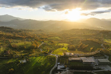Luftaufnahme einer Berg- und Hügellandschaft mit Weinbergen und Häusern auf dem Land bei Sonnenuntergang in Herbstfarben, Irpinia, Avellino, Kampanien, Italien. - AAEF25759