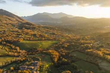 Aerial view of a mountains and hills landscape with vineyard and countryside houses at sunset in autumn colours, Irpinia, Avellino, Campania, Italy. - AAEF25771
