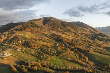 Aerial view of a mountains and hills landscape with vineyard and countryside houses at sunset in autumn colours, Irpinia, Avellino, Campania, Italy. - AAEF25772