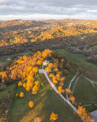 Aerial view of a mountains and hills landscape with vineyard and countryside houses at sunset in autumn colours, Irpinia, Avellino, Campania, Italy. - AAEF25775