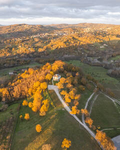 Luftaufnahme einer Berg- und Hügellandschaft mit Weinbergen und Häusern auf dem Land bei Sonnenuntergang in Herbstfarben, Irpinia, Avellino, Kampanien, Italien. - AAEF25775