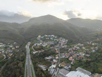 Luftaufnahme von Fahrzeugen auf der Landstraße über das Tal mit Bergen bei Sonnenuntergang in Serino, Irpinia, Avellino, Kampanien, Italien. - AAEF25843