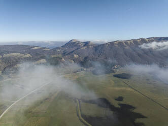 Luftaufnahme des Laceno-Sees (Lago Laceno), eines Stausees auf einem hoch gelegenen Berg mit niedrigen Wolken und Nebel in Bagnoli Irpino, Avellino, Irpinia, Kampanien, Italien. - AAEF25897