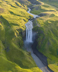 Aerial drone view of Skógafoss waterfall during sunrise in summer time, Southern Iceland. - AAEF25936