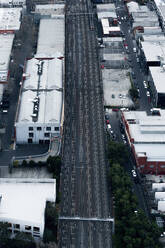 Luftaufnahme einer Eisenbahnlinie, die ein Industriegebiet durchschneidet und die Verkehrsinfrastruktur und Industriegebiete hervorhebt, Australien. - AAEF26004
