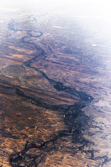 Luftaufnahme eines ausgetrockneten Flusses, der sich durch eine Wüstenregion schlängelt und die Trockenheit der Landschaft verdeutlicht, Australien. - AAEF26027