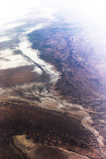 Luftaufnahme einer Salzebene, die sich in eine weite Wüstenlandschaft erstreckt, Australien. - AAEF26031