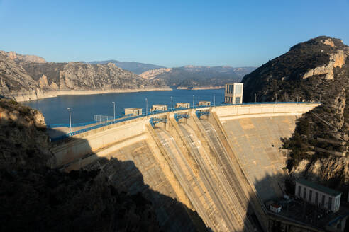 Ein riesiger Staudamm mit deutlich reduziertem Wasserstand in einem Gebirgsgebiet, der die möglichen Auswirkungen von Dürre verdeutlicht - ADSF52692