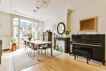 Dieses Bild zeigt ein geräumiges, helles Wohnzimmer im Vintage-Stil mit einem Essbereich und einem klassischen Klavier. - ADSF52719