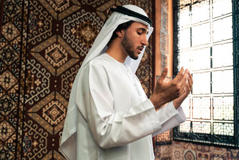 Ein emiratischer Mann in Kandura-Kleidung verbringt Zeit in einem traditionellen arabischen Haus in Dubai - DMDF09292