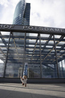 Dancer doing handstand in front of building - NGF00811