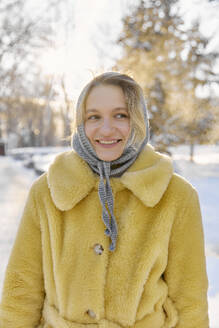 Lächelnde junge Frau mit Kopftuch und Pelzmantel im Winter - SANF00172