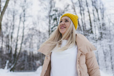 Lächelnde Frau in warmer Kleidung im Winterwald - OLRF00118