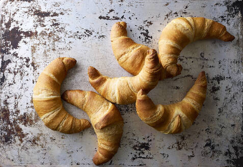 Studioaufnahme von hausgemachten Croissants auf zerkratztem Backblech - KSWF02369