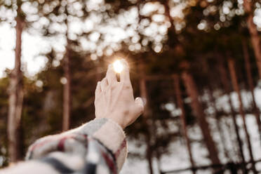 Hand einer Frau, die sich dem Sonnenlicht entgegenstreckt - EBBF08303