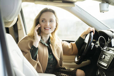 Schöne Frau, die im Auto sitzend mit einem Smartphone spricht - NJAF00738