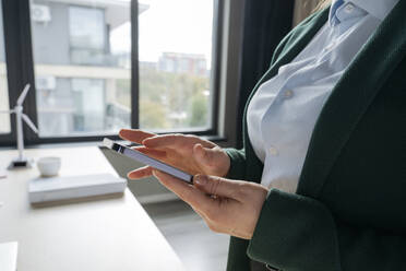 Geschäftsfrau benutzt Smartphone im Büro - OSF02364