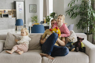 Father sitting with children on sofa at home - SEAF02212