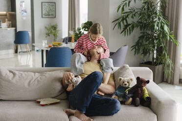 Father and daughter spending leisure time together on sofa at home - SEAF02213