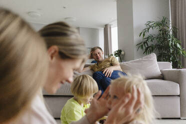 Glücklicher Mann betrachtet Familie im Wohnzimmer zu Hause - SEAF02228